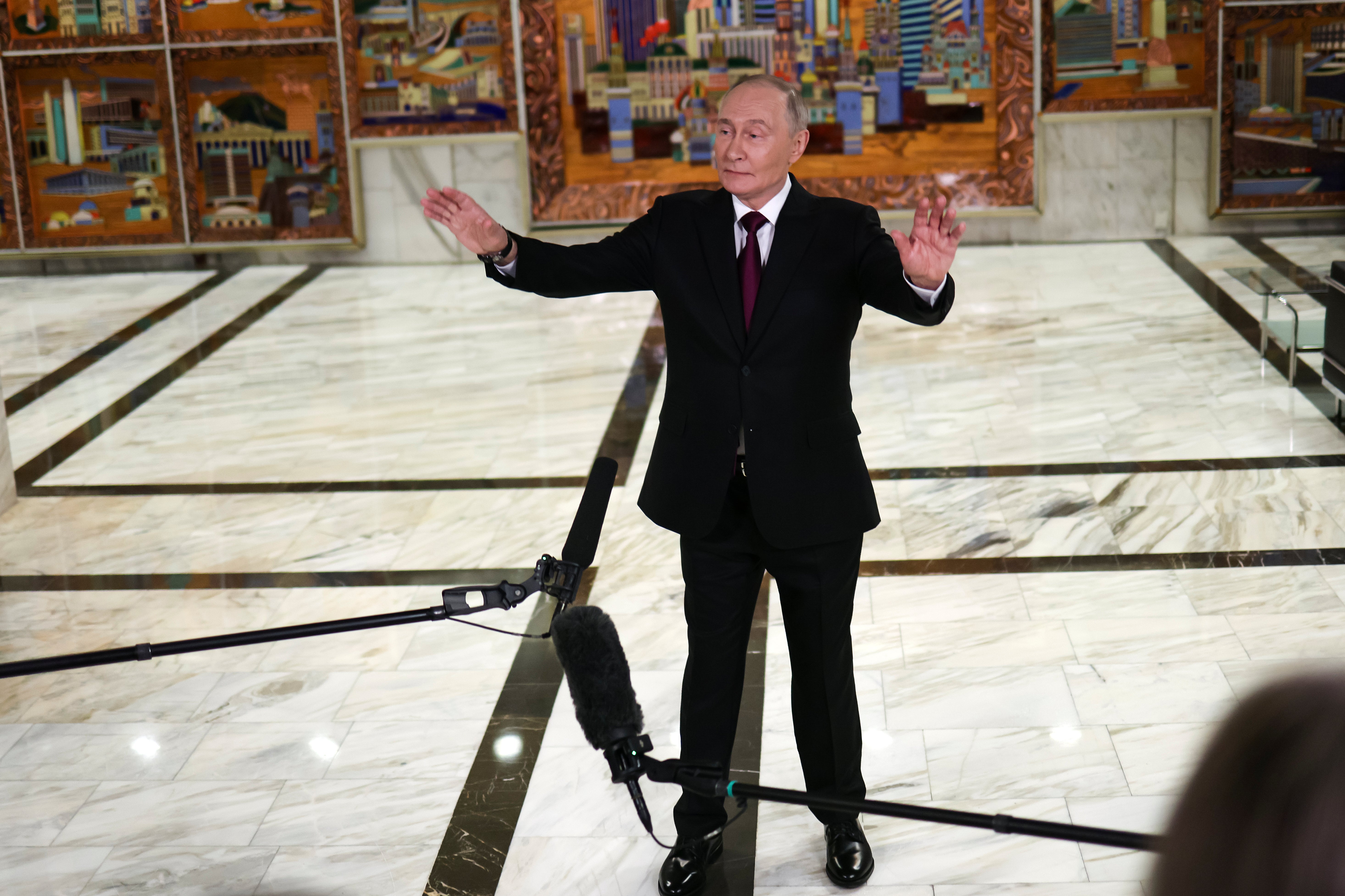 Russian president Vladimir Putin gestures speaking to journalists after the plenary session of the VTB 