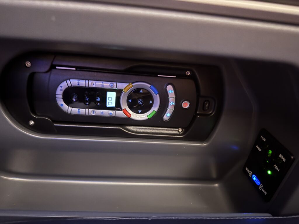 IFE remote control tucked into the side of the seat