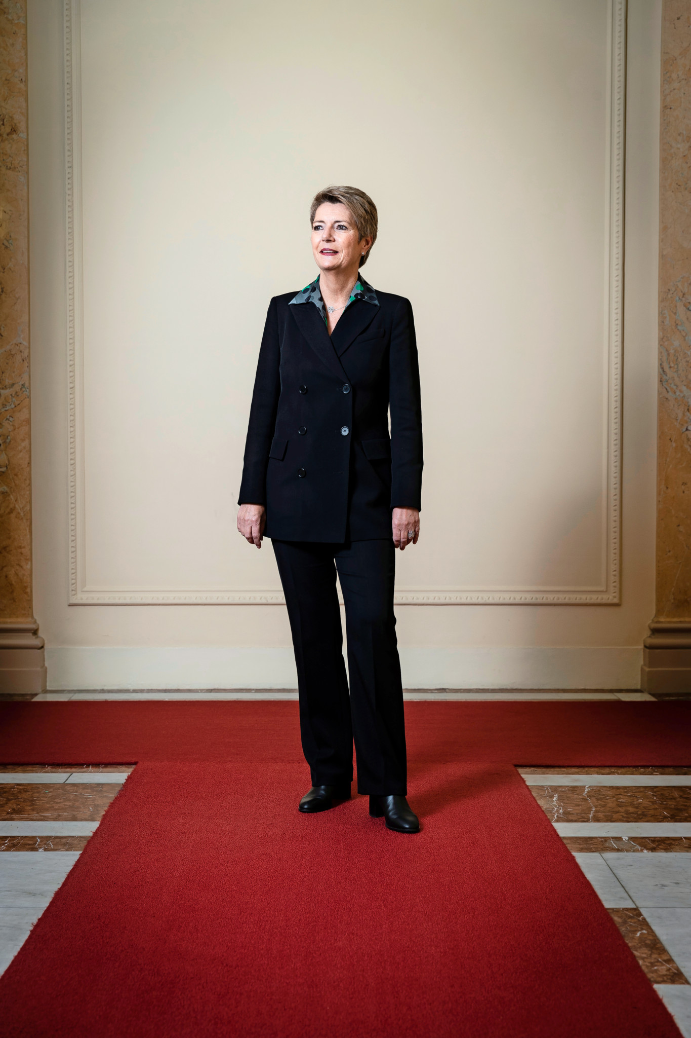 Bundesrätin Karin Keller-Sutter steht am 30. November 2023 in Bern auf einem roten Teppich vor einer neutralen Wand.