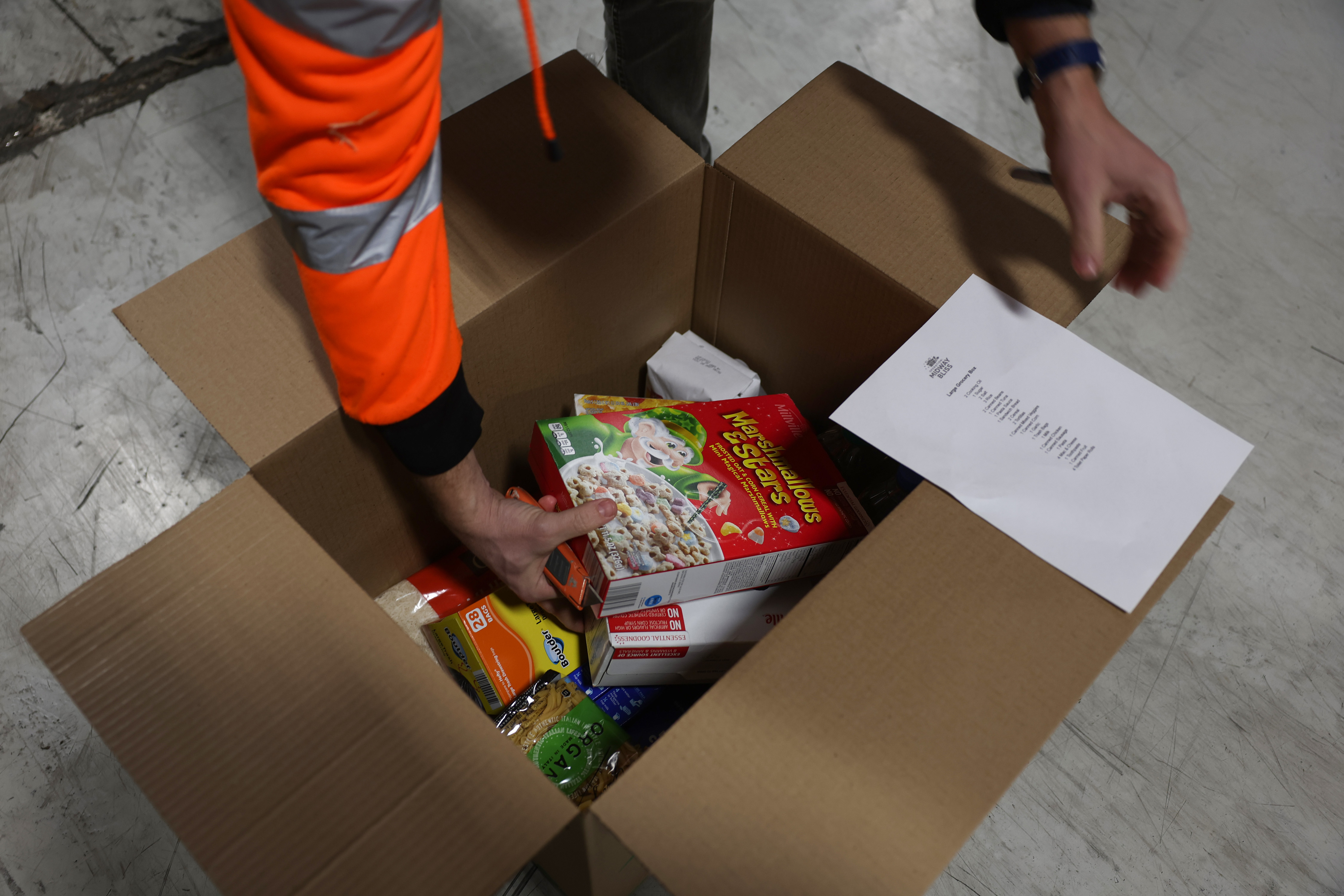 Brendan Krahl shows grocery items included for a food distribution...