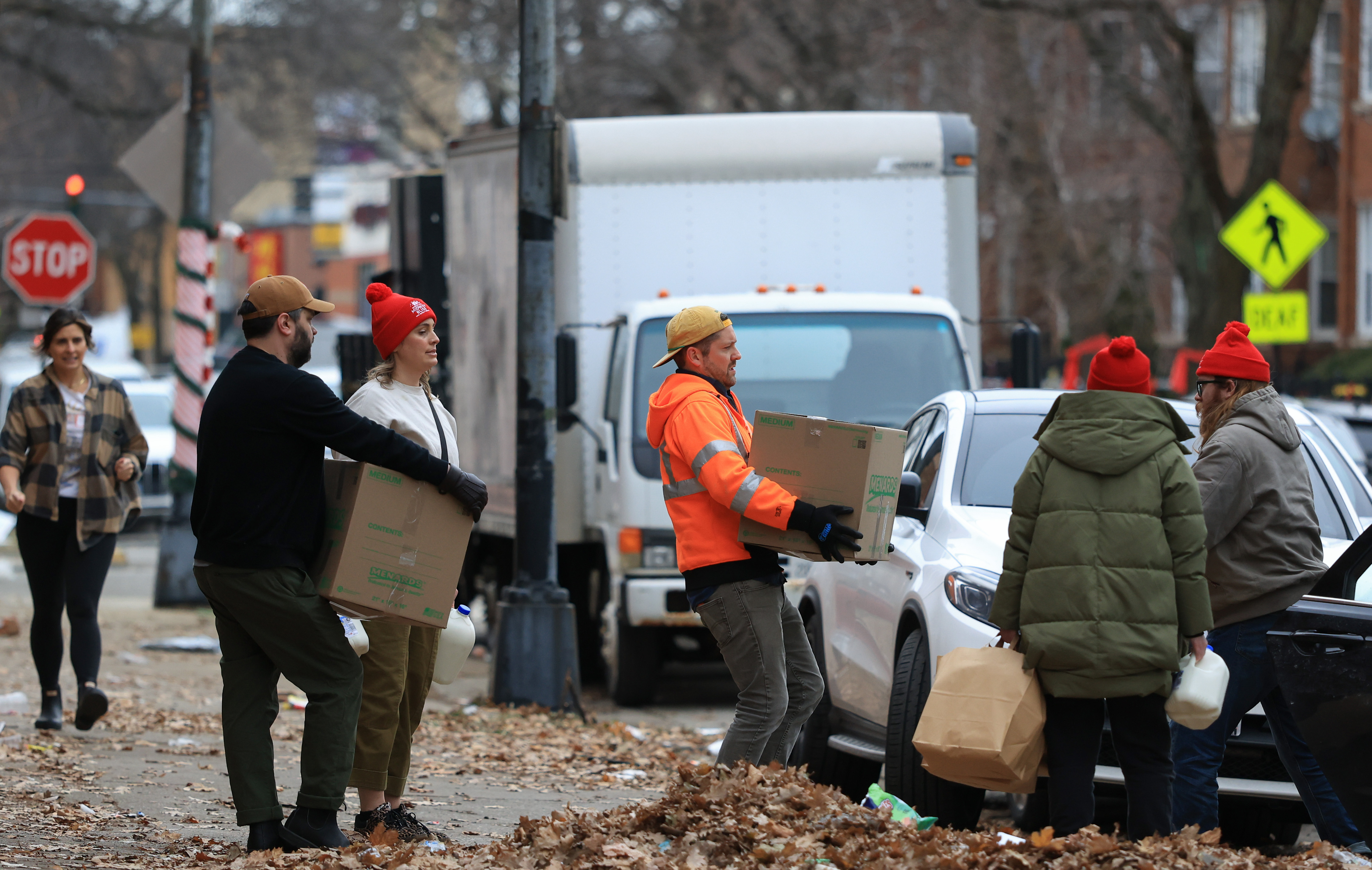 Brendan Krahl, center, and fellow volunteers wait to load groceries...