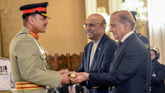 Prime Minister Shehbaz Sharif (R) and President Asif Ali Zardari (C) jointly conferring the Baton of Field Marshal on Chief of Army Staff Asim Munir.(AFP)