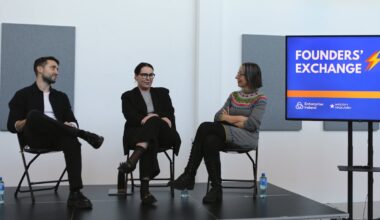 One man and two women sitting on a stage at a panel discussion.