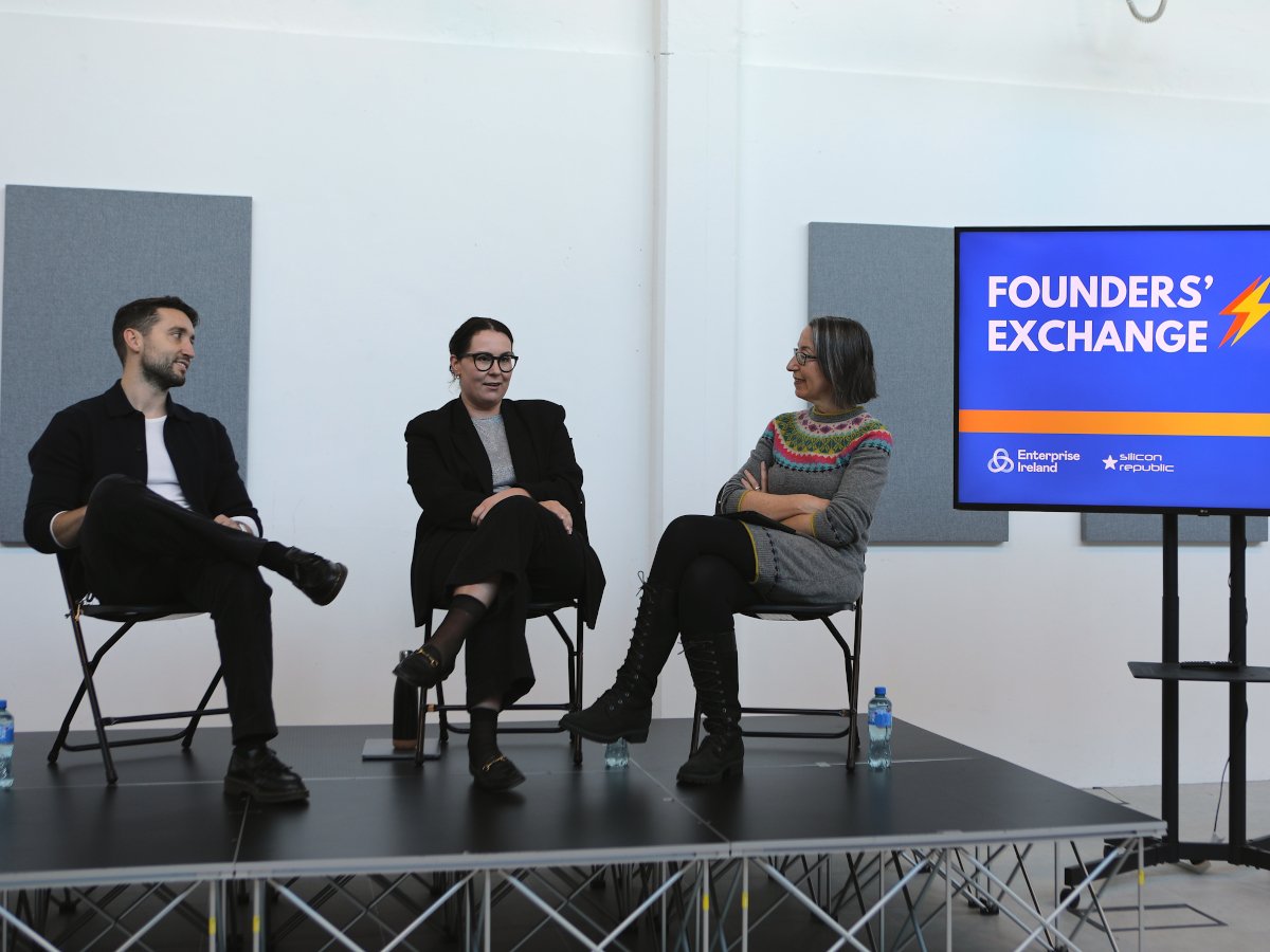 One man and two women sitting on a stage at a panel discussion.