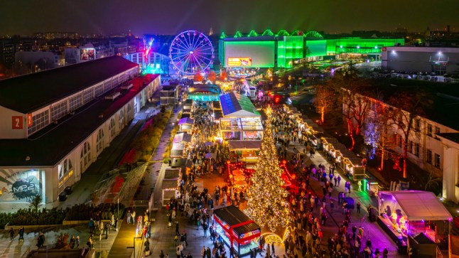 Aerial view of Poznan Christmas Market at MTP with Ferris wheel, illuminated stalls and crowds creating a festive atmosphere