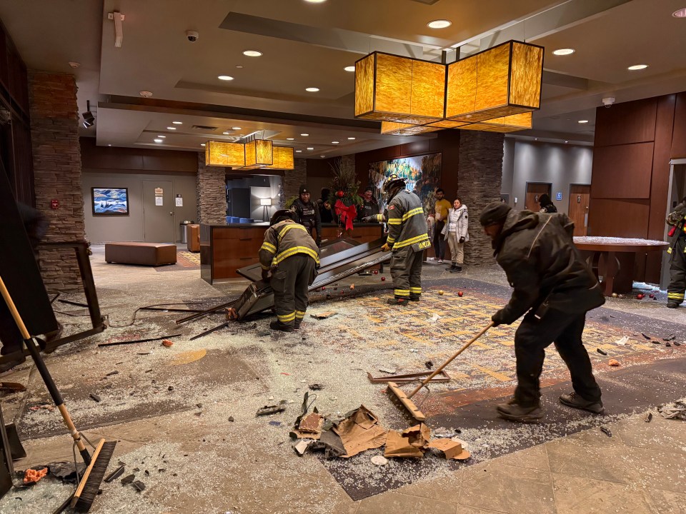 Staff and emergency personnel clear wreckage from the scene, including one of the hotel's doors. Ollie Williams/Cabin Radio