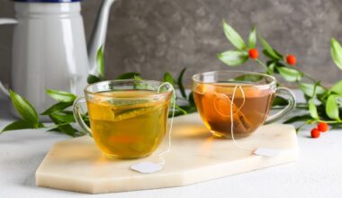 Cups of aromatic green and black tea on light background