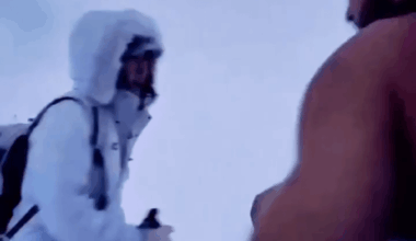 Polish man walks up a snowy mountain without excessive clothing.