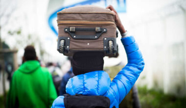 person carrying luggage on top of his head