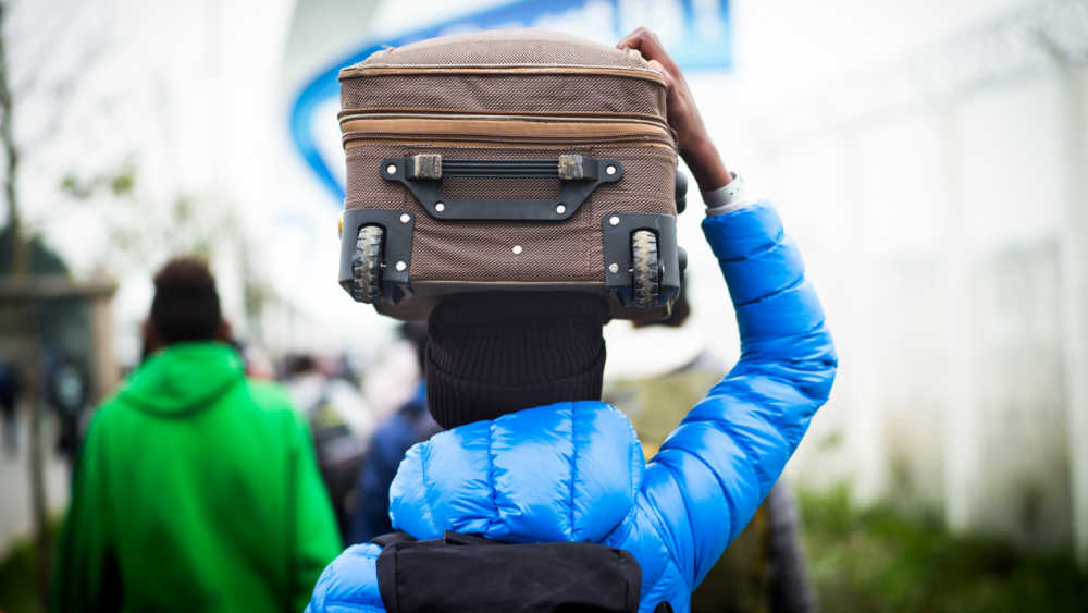person carrying luggage on top of his head
