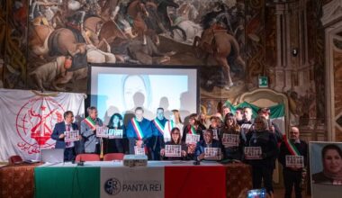 NCRI supporters, Italian local officials and civil society representatives gather in Savigliano’s historic Taffini Hall on 5 December 2025, holding images of Iranian political prisoners