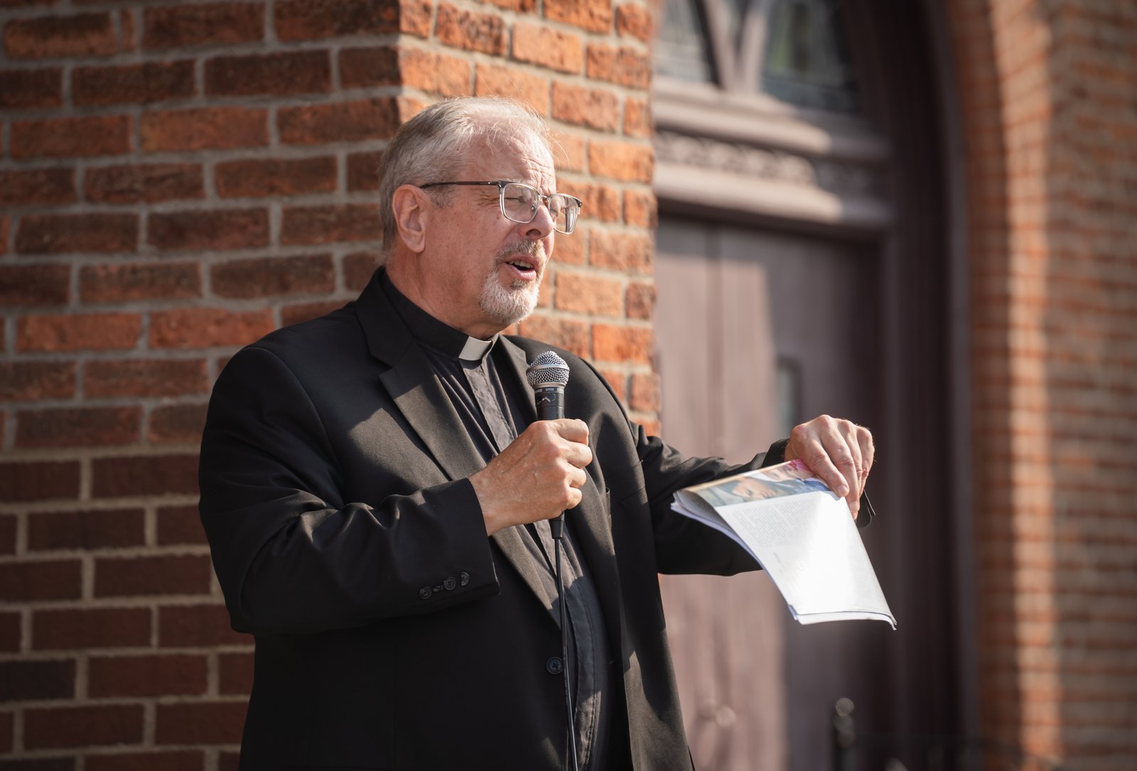 Fr. David Buersmeyer, chaplain of the Detroit-based Strangers No Longer, speaks in front of Most Holy Trinity Parish in Detroit's Corktown neighborhood before a Strangers No Longer-organized procession to Immigration and Customs Enforcement office on July 14.