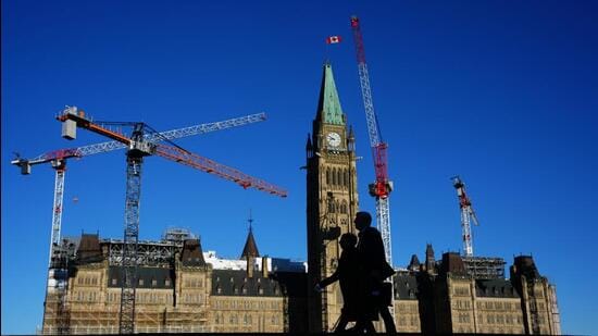 People walk past the Peace Tower on Parliament Hill in Ottawa, Canada. (AP)