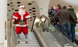 Yevdokym Serdiuk — a veteran of the Russian–Ukrainian war who lost his legs in combat — rides an escalator dressed as Santa Claus at a Kyiv shopping mall on December 12, 2025. Serdiuk served with the 56th Motorized Brigade and now works as a prosthetic walking instructor at the Tytanovi rehabilitation center.