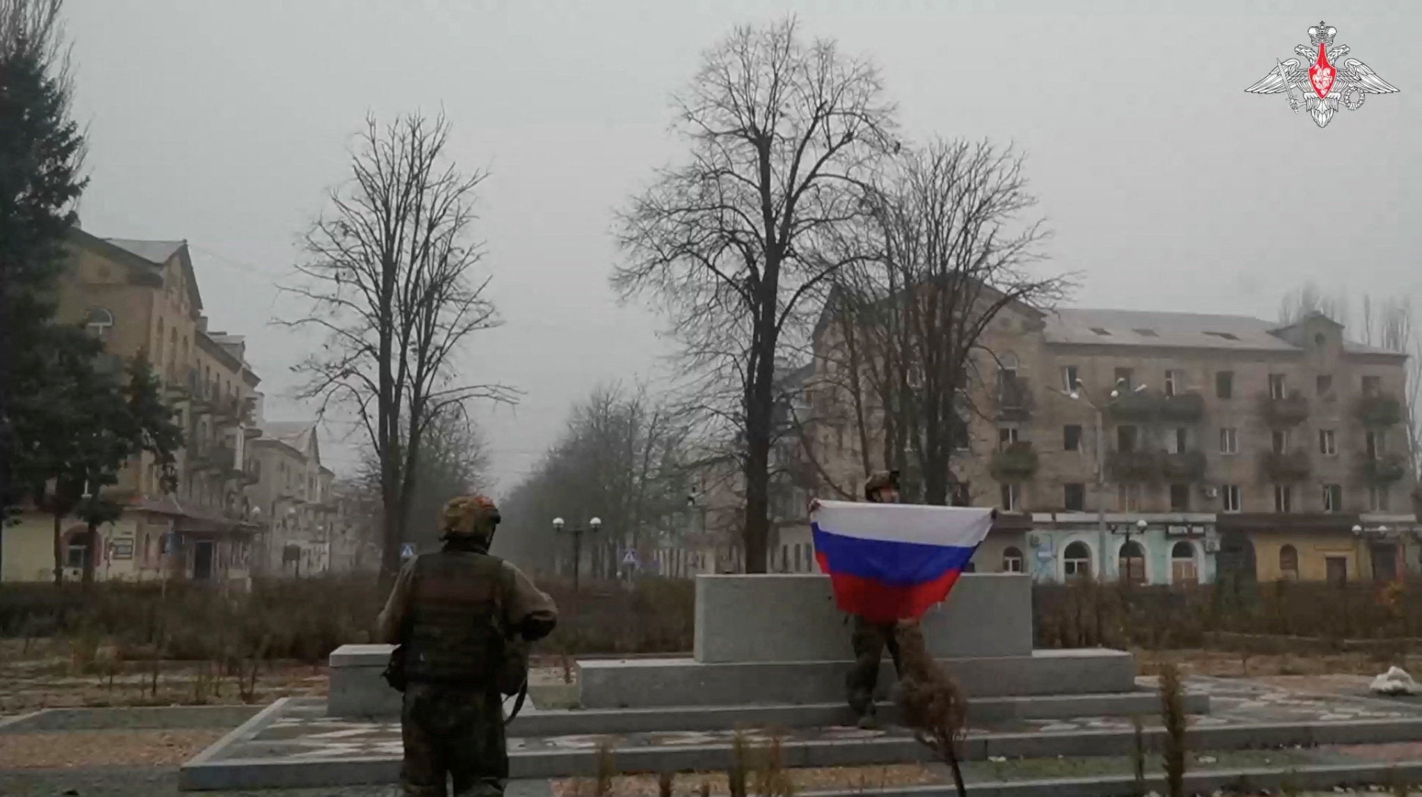 A soldier holds a Russian flag in Pokrovsk in Donetsk Region, Ukraine in this screengrab from video