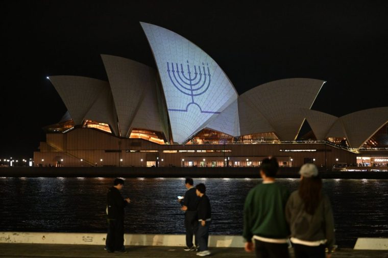 SYDNEY, AUSTRALIA - DECEMBER 15: The Hanukkah menorah, a nine-branched candelabrum lit during the eight day Jewish holiday is projected onto the sails of the Sydney Opera House on December 15, 2025 in Sydney, Australia. Police say at least 16 people, including one suspected gunman, were killed and more than 40 others injured when two attackers opened fire near a Hanukkah celebration at the world-famous Bondi Beach, in what authorities have declared a terrorist incident. (Photo by James D. Morgan/Getty Images)