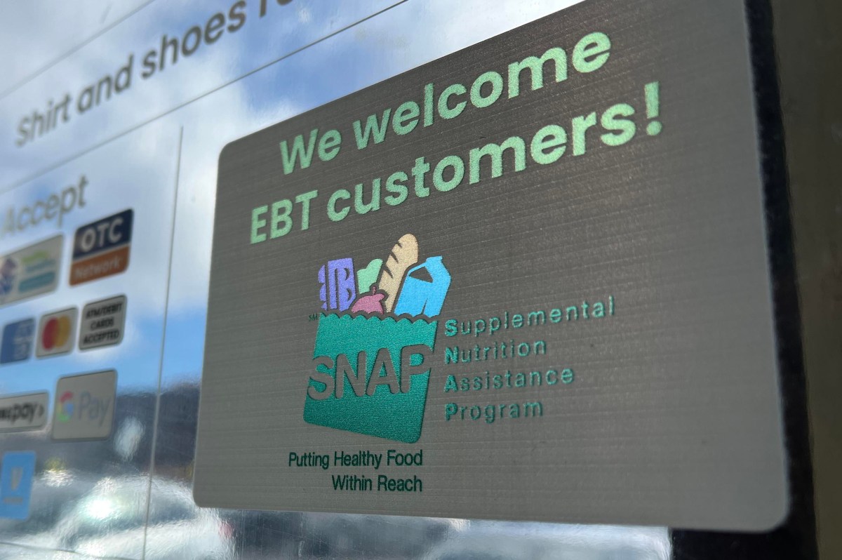 A sign on a glass door reads "We welcome EBT customers!" with a SNAP logo and text for the Supplemental Nutrition Assistance Program. Payment method stickers are visible on the left.