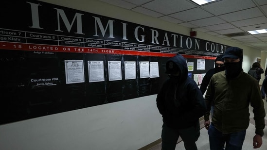Masked federal agents walk in a hallway at the New York Federal Plaza Immigration Court inside the Jacob K. Javitz Federal Building in New York.(AFP)