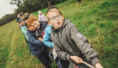 Bildbeschreibung: Mehrere Kinder die an einem Seil ziehen.
