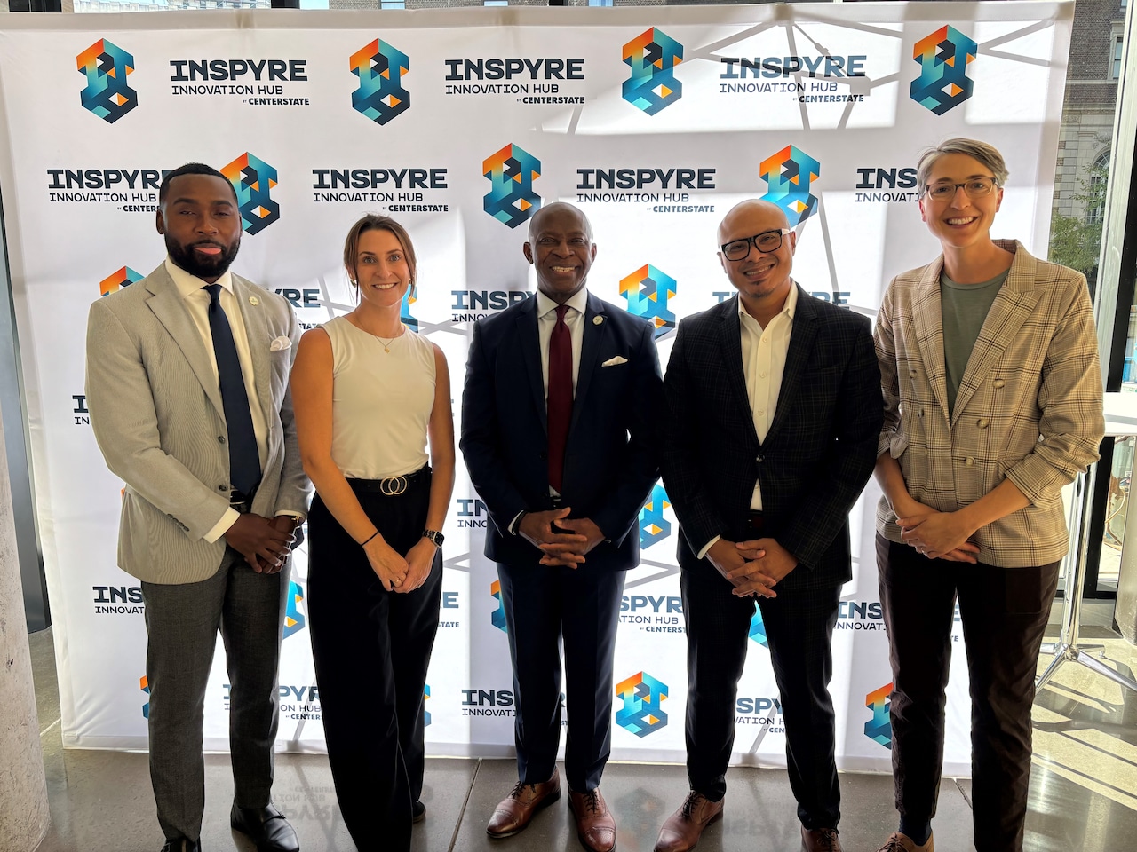Five people pose for a photo at INSPYRE Innovation Hub