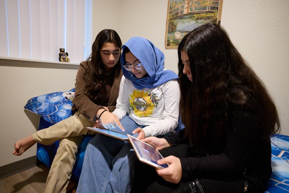 Middle school girls, including Maryam (center), daughter of Afghan artist Aziz Tokhi, study at home in Sacramento.