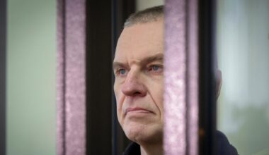 Der inhaftierte belarussische Journalist Andrzej Poczobut im Seitenporträt hinter einem Gitter.