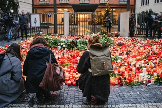 Prague, Czech Republic – December 22, 2023: People gather outside Charles University’s Carolinum a day after a shooting that killed 14 students and staff. Shutterstock/Bob Roz