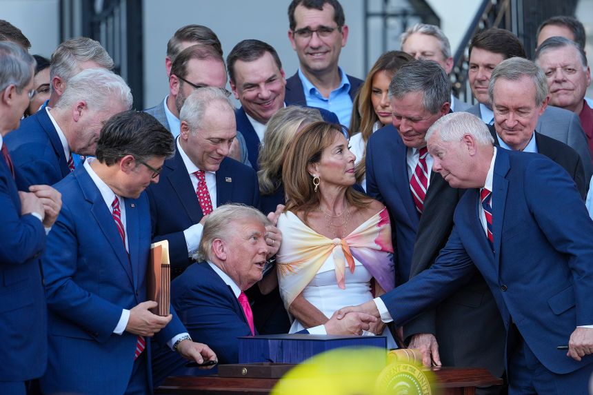 President Donald Trump, joined by Republican lawmakers, signs the 
