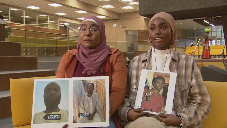Fatma Khairy, left, with her daughter, Elaf, right, are originally from Sudan and now live in Regina. Fatma holds a sign showing two pictures of her brother-in-law, before and after being held by the Rapid Support Forces in Sudan. Elaf holds a picture of her cousin, who was shot and killed in his own bakery.