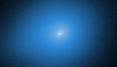 A white light of the comet 3I/ATLAS is surrounded by a blue glow against a black background