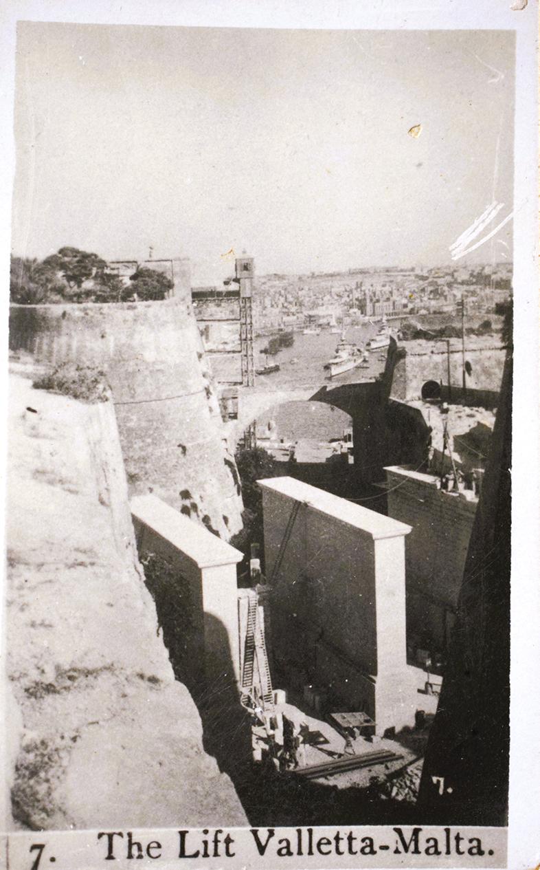 A cigarette card titled ‘The Lift’, showing Duke of York Avenue in construction.