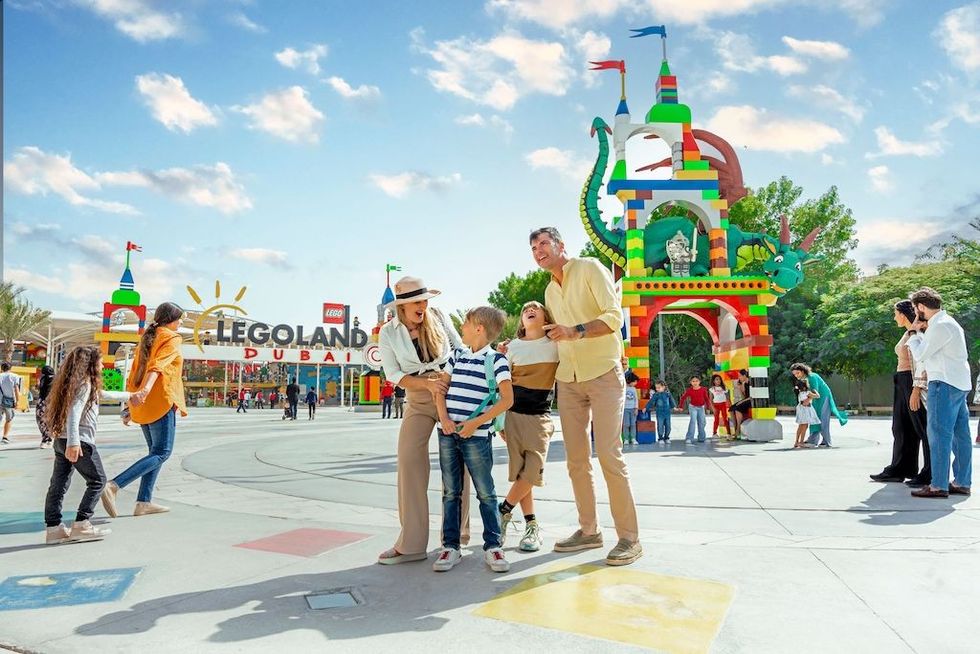 Family enjoying a day at Legoland Dubai with colorful structures and archway.