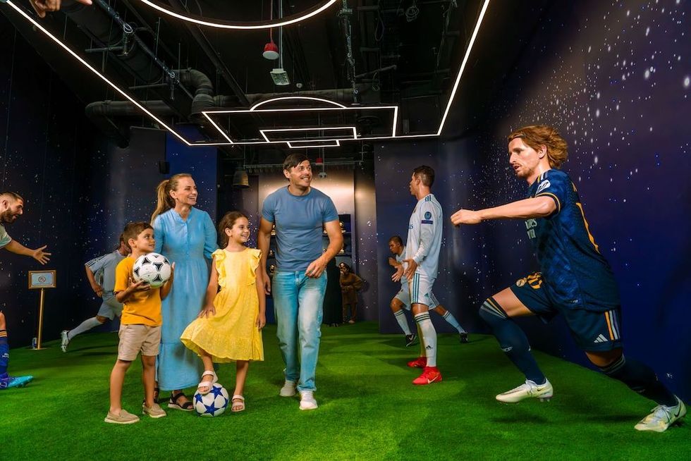 Family enjoys a soccer-themed interactive exhibit with life-size player models.
