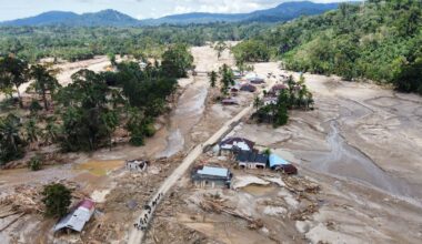 People walk along a road in a village affected by a flash flood in Batang Toru, North Sumatra, Indonesia, Monday, Dec. 1, 2025. (AP Photo/Binsar Bakkara)