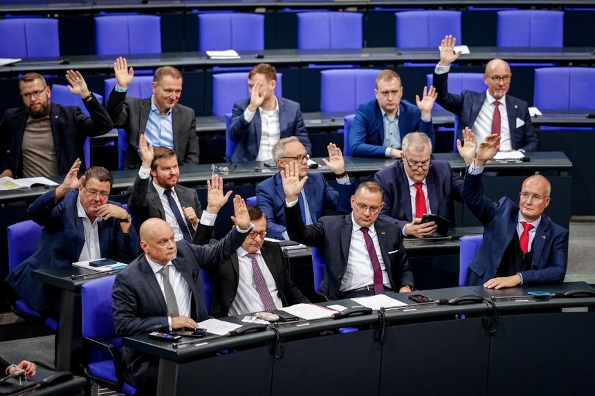 Alternative for Germany MPs with Tino Chrupalla (front, second from right), AfD federal and parliamentary group leader, raise their hands for a vote in the plenary chamber of the Bundestag on December 19, 2025, in Berlin.
