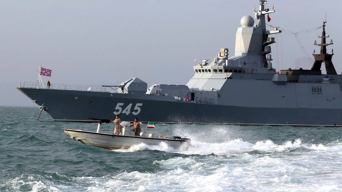 A Russian warship and an Iranian army speed boat attend a joint naval exercise on Tuesday. (AP/Iranian Army)