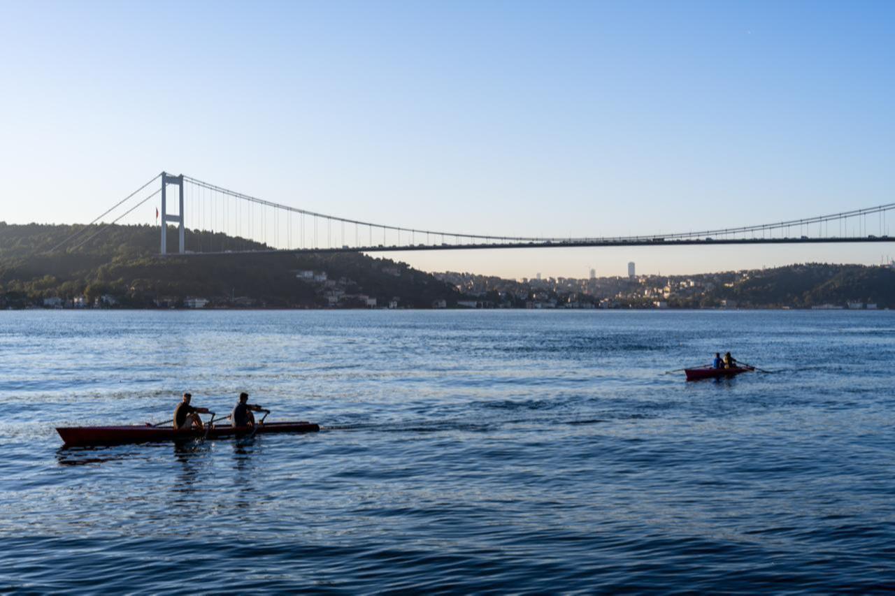 Rowers glide across the waters of the Bosphorus behind the Bosphorus Bridge, in Istanbul Türkiye, accessed on Dec. 5, 2025. (Photo via Adobe Stock)