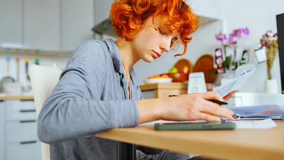 Eine junge Frau sitzt an einem Tisch