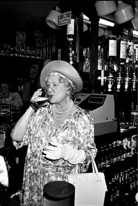 The queen mum sucks one back in Limehouse, 1987.