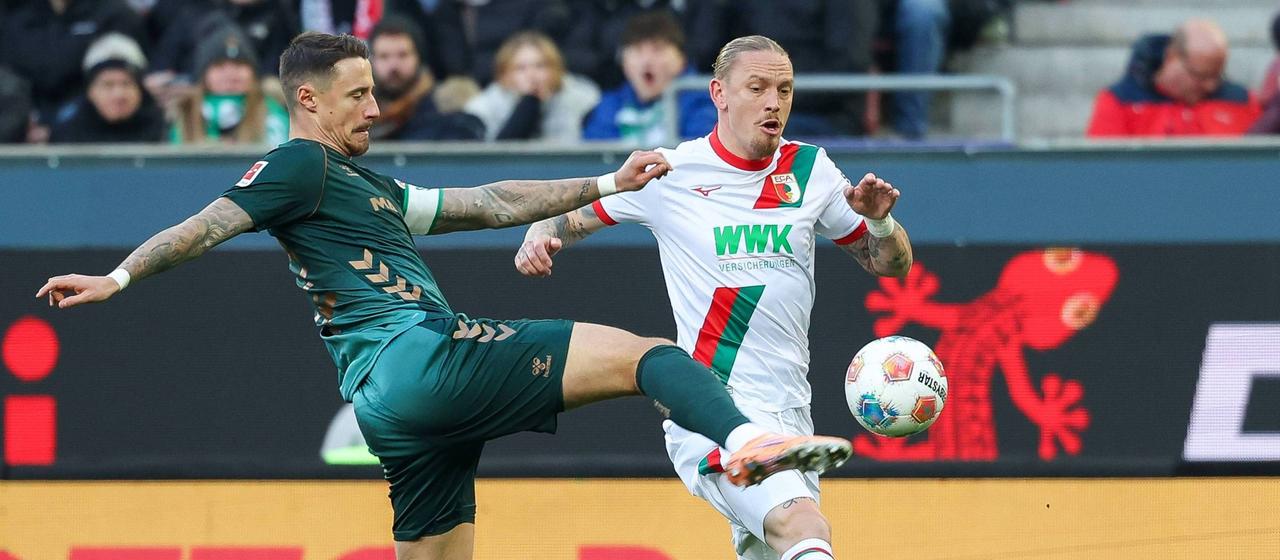 Fußballprofi Marco Friedl (l.) im Bundesligaspiel beim FC Augsburg im Zweikampf mit Marius Wolf