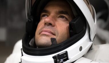 head shot of a male astronaut wearing a white spacesuit helmet