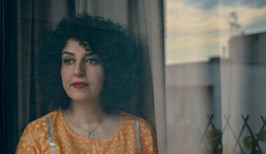 Die Friedensnobelpreisträgerin Narges Mohammadi steht mit gelber Bluse vor einem Fenster.
