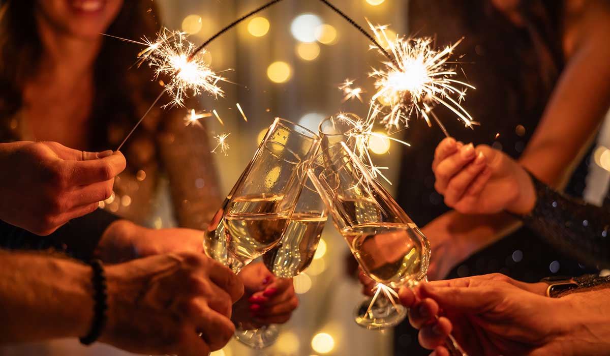 Sparkling sparklers in the hands. Playing firework to celebrate winter holidays with friends at the party. Magic New Year, Christmas.