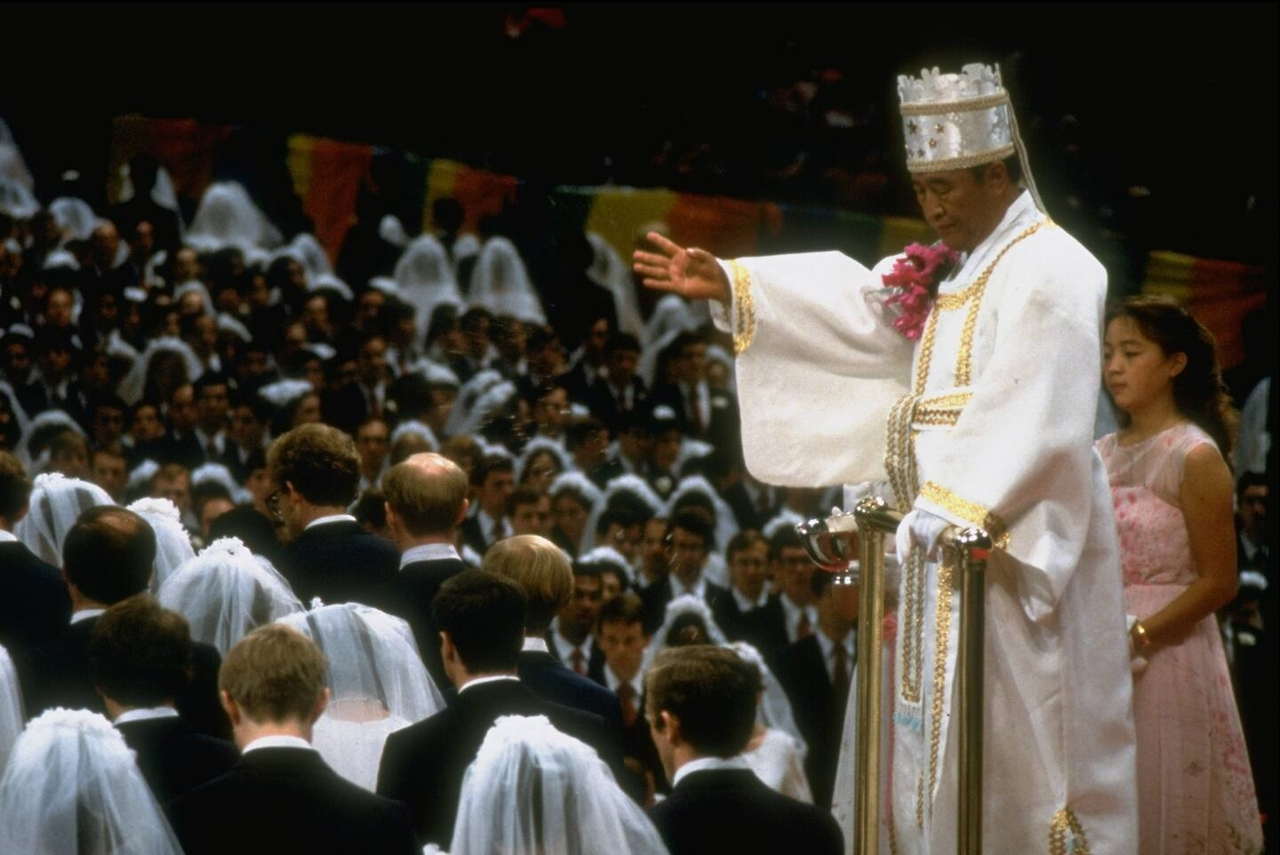 Unification Church former leader and current head Han Hak-ja's late husband, Sun Myung Moon, presides over a mass wedding ceremony in this undated photo. (Getty Images)