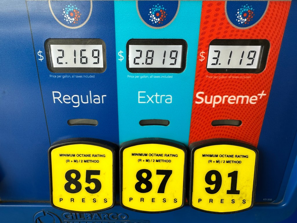 A gas pump displaying prices per gallon for Regular at $2.169, Extra at $2.819, and Supreme+ at $3.119.