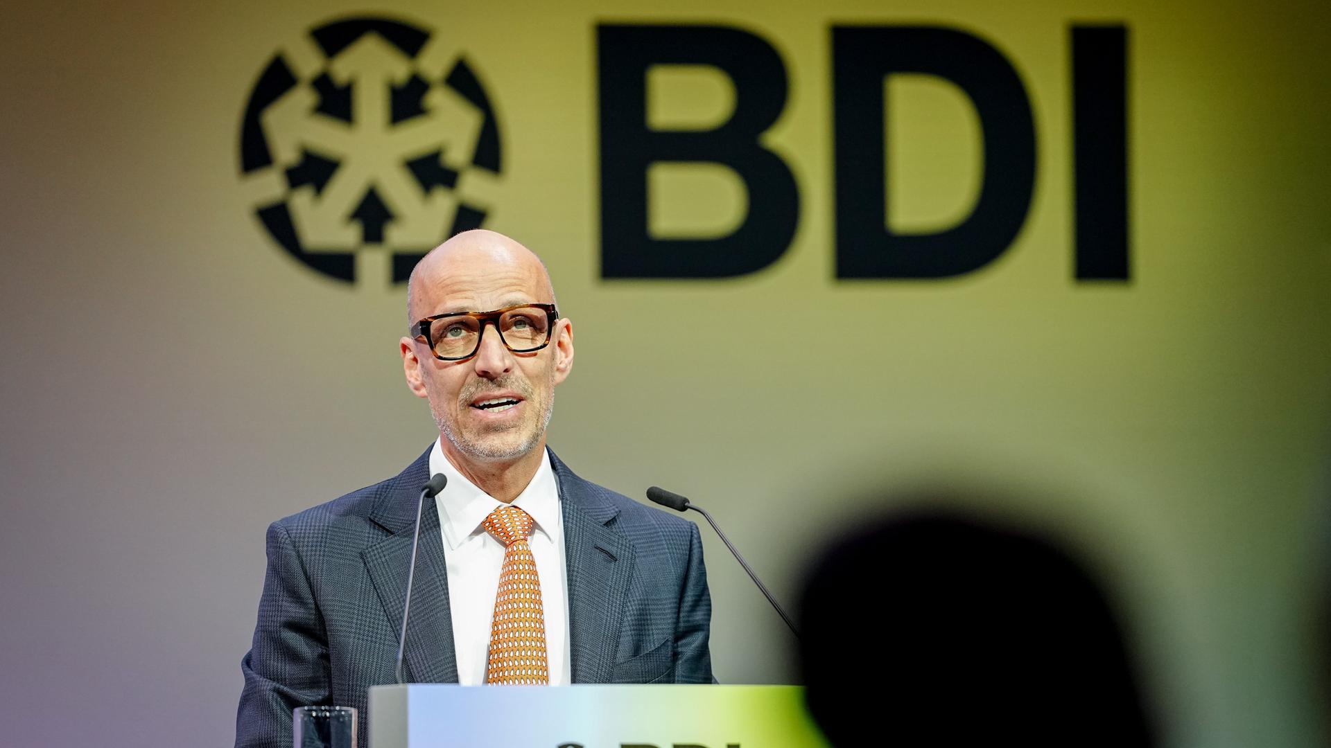 Peter Leibinger, Präsident des Bundesverbands der Deutschen Industrie, spricht in ein Mikrofon vor Publikum. 