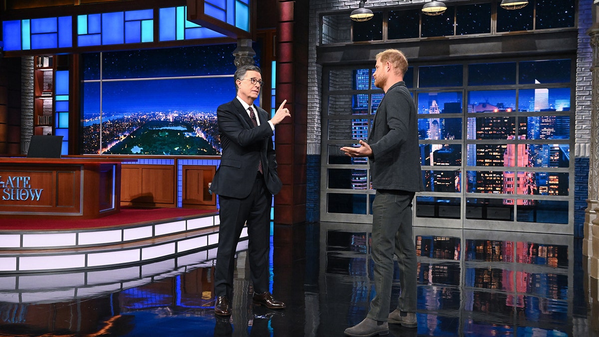 Prince Harry and Stephen Colbert seemingly debating but really joking on stage during filming.