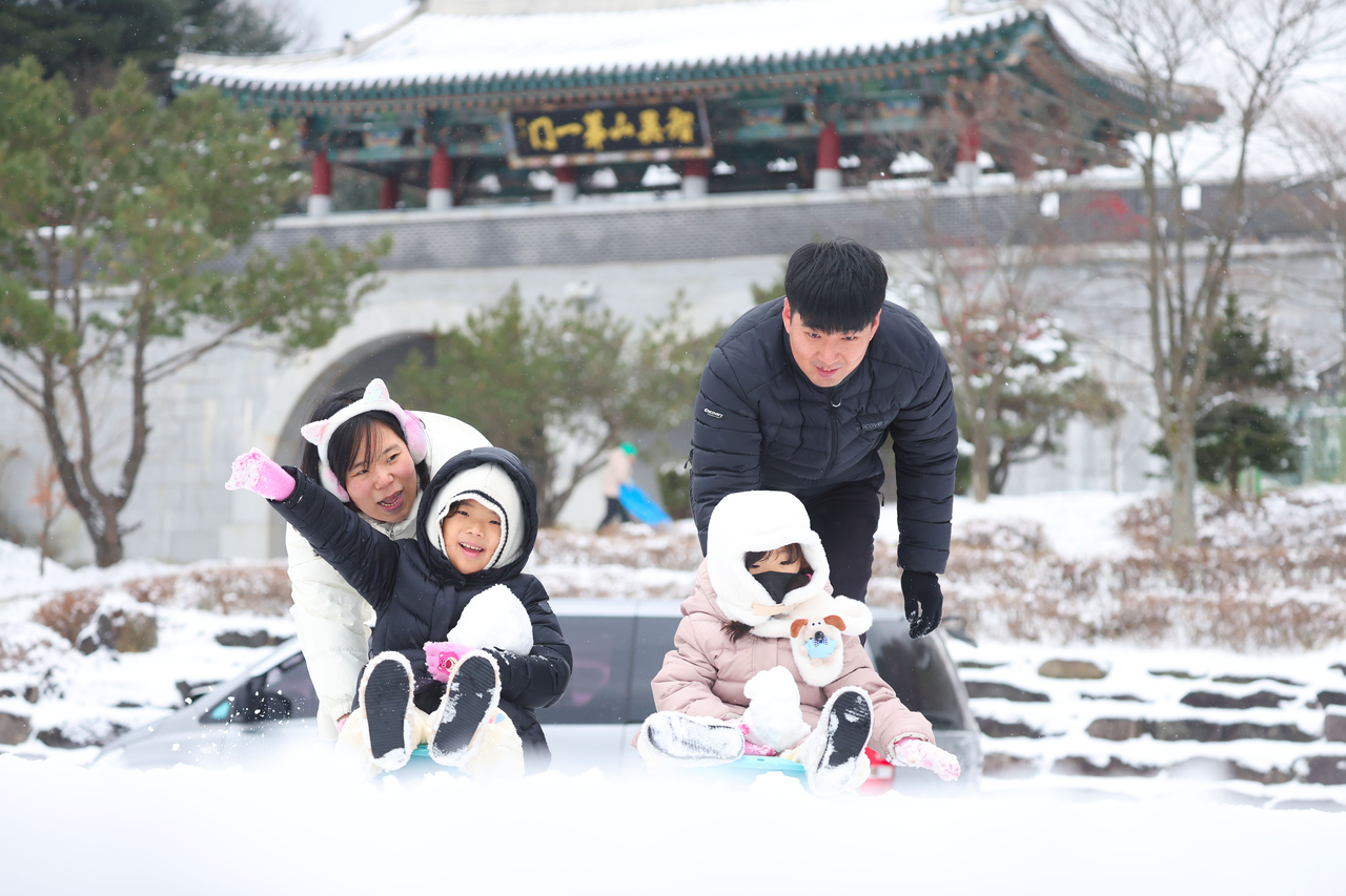 A family enjoys ice sliding in Hamyang, South Gyeongsang Province, on Dec. 14. (Yonhap)