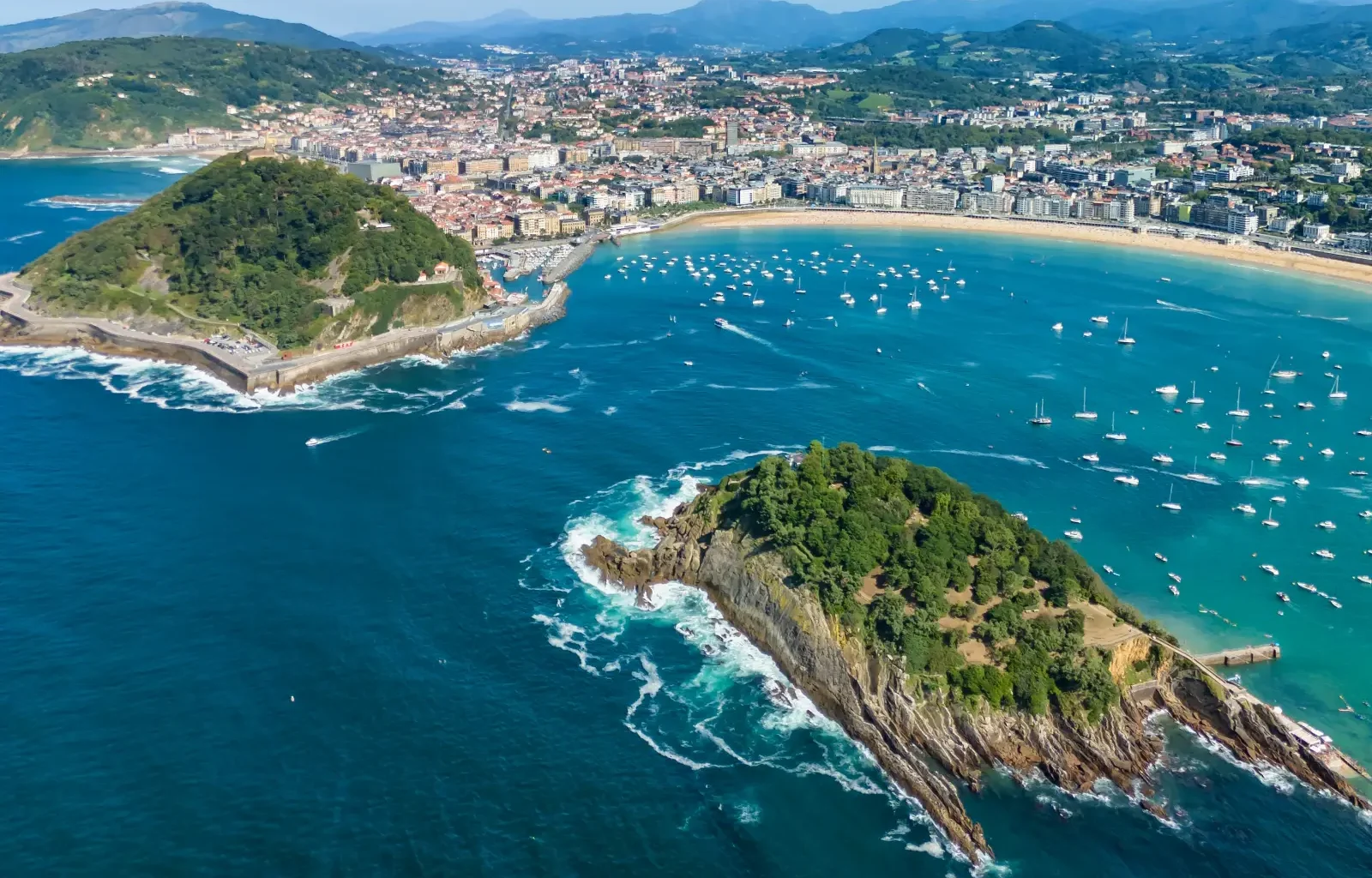 Aerial view of San Sebastián bay with turquoise water, Santa Clara Island and Donostia city.