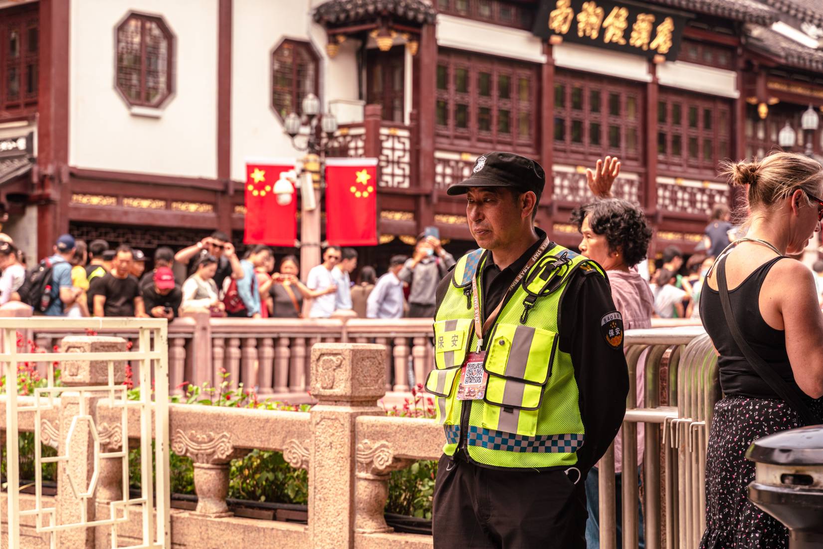 A police officer stands guard at Yuyuan Garden in Shanghai, China, maintaining order amid crowds of tourists and locals